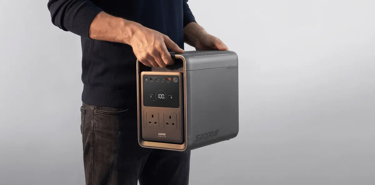 A person carrying the Anker SOLIX S2000 portable power station